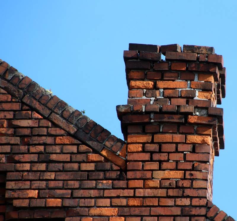 Damaged chimney on an Seal Beach home showing cracks and missing mortar